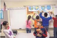  ?? RODRIGO ABD/ASSOCIATED PRESS ?? Students take a break in a fourth grade classroom at Columbus Elementary School in 2017. New Mexico’s test scores in math and reading remain below the national average.