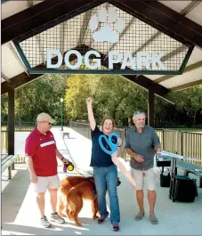  ?? Janelle Jessen/Herald-Leader ?? Renae Sassnett, executive assistant for Simmons Foods, center, celebrated with Ken Krafft, left, and Siloam Springs mayor John Mark Turner, right, after cutting the ribbon for the grand opening of the Tails and Trails Dog Park.