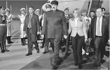  ??  ?? Maduro walks with his wife Cilia Flores upon their arrival at the airport in Beijing, China. Maduro hailed China as a ‘big sister’ as he prepared to meet with Chinese leader Xi Jinping, hoping to broker economic deals for his crisis-hit country. — Reuters photo