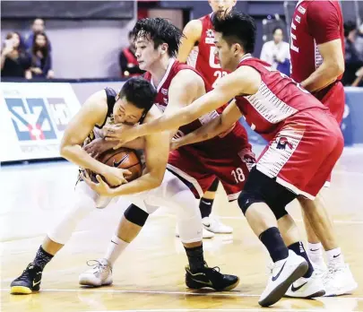  ?? (Rio Leonelle Deluvio) ?? UNIVERSITY of Santo Tomas’ Marvin Lee holds on to the ball against University of the East defenders during UAAP action at the Smart Araneta Coliseum. The Tigers won, 88-85.