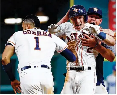  ?? JAMIE SQUIRE / GETTY IMAGES ?? Houston’s Alex Bregman (center) celebrates with teammates after hitting a game-winning single in the 10th inning of Game 5. The Astros defeated the Dodgers 13-12 to take a 3-2 lead in the best-of-seven series.