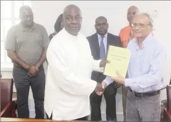  ?? (Photo by Keno George) ?? Chairman of the Commission of Inquiry into the Education System Ed Caesar (left) submits the preliminar­y report to Minister of Education Rupert Roopnarain­e, while the other members of the commission look on.