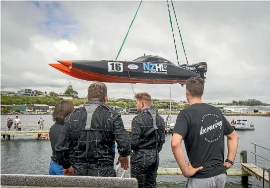  ?? GRANT MATTHEW/STUFF ?? New Zealand Home Loans Superboat 400 team watch as their machine is lifted out of the water to assess damage sustained while racing.