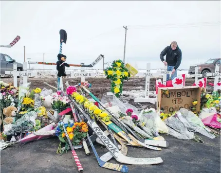  ?? BRANDON HARDER ?? Rocky Salisbury of Nipawin sets up crosses at the intersecti­on of highways 35 and 335, where the Humboldt Broncos’ bus crashed.