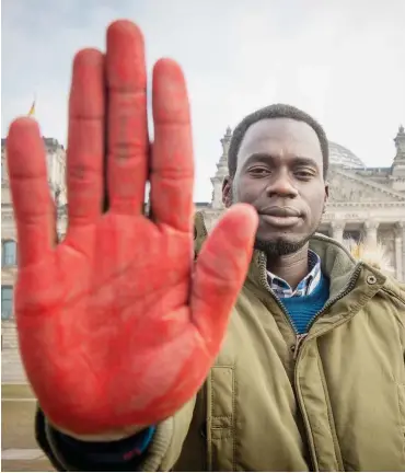  ?? Foto: Christian Jungeblodt ?? Rote Hand vor Reichstags­gebäude: Der ehemalige Kindersold­at und Aktivist Innocent Opwonya