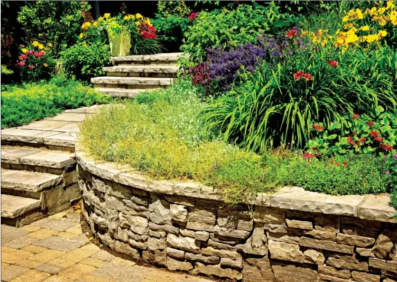  ??  ?? A stone retaining wall looks classic and natural — particular­ly when it’s installed by a skilled stonemason. (Dreamstime)