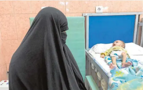  ?? // M. A. ?? Una madre afgana mira a su bebé, en la Unidad de Desnutrici­ón del Hospital Infantil de Indira Ghandi, en Kabul