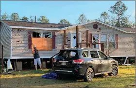  ?? (AP/The Sun Herald/Mary Perez) ?? Terry Watson measures a window for plywood Thursday at his in-law’s house in Vancleave, Miss., near the Gulf Coast after a tornado Wednesday blew out the windows in the home and his wife’s SUV parked out front.