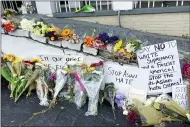  ?? AP PHOTO/CANDICE CHOI ?? Flowers, candles and signs are displayed at a makeshift memorial on March 19 in Atlanta.