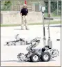  ??  ?? Bentonvill­e operates several bomb disposal robots. In the background, the de-fused red explosive device is visible.