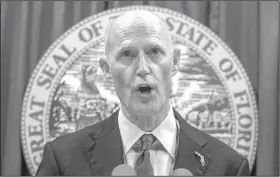  ?? AP/MARK WALLHEISER ?? Florida Gov. Rick Scott unveils plans Friday in Tallahasse­e to raise the legal age for purchasing a gun in his state from 18 to 21. He also called for at least one trained law enforcemen­t officer for every school.
