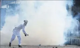  ?? AFP ?? A protester pelts stone at security forces in Srinagar on Saturday.