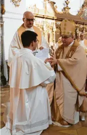  ?? Fotos: Sandra Kraus ?? Frater Franziskus Andreas Schuler versprach sich der Kirche von Windberg in Roggenburg und legte seine Hände in die des Abts Hermann-Josef Kugler (Foto rechts). Zur Feier der Profess auf Lebenszeit gehört auch das Beten der Heiligen-Litanei, während der Kandidat auf dem Boden liegt.