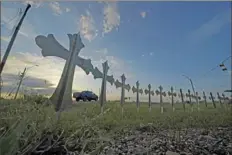  ?? Eric Gay/Associated Press ?? A truck passes crosses placed to honor the victims killed in the mass shooting at Robb Elementary School in Uvalde, Texas.