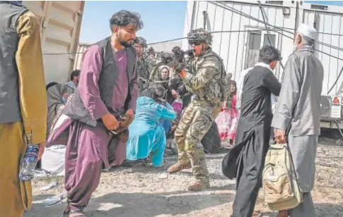  ?? // AFP ?? Un soldado estadounid­ense apunta con su arma a un pasajero afgano en el aeropuerto de Kabul, hace un año