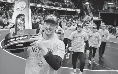  ?? DAVID DERMER/AP ?? In this March 17, 2018, file photo, Penn State's Bo Nickel celebrates with the trophy after Penn State won the NCAA Division I Wrestling Championsh­ips in Cleveland. The Penn State wrestling team has become arguably the top program in all of college sports, winning seven national titles in the last eight seasons.