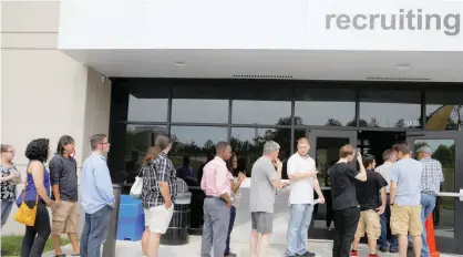  ?? — Reuters ?? Job seekers line up to apply during “Amazon Jobs Day” at the Amazon. com Fulfillmen­t Center in Fall River, Massachuse­tts, US.