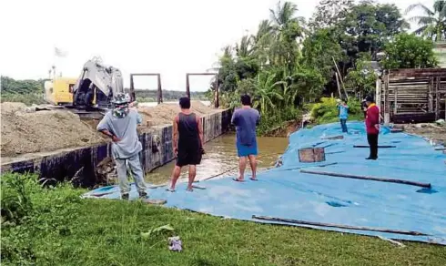  ??  ?? SYARIKAT pengorek pasir menimbus batu dan pasir pada tebing Sungai Labuk di Kampung Tagas-Tagas, Beluran selepas berlaku runtuhan tanah menyebabka­n rumah penduduk terjejas.