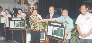  ??  ?? Naroden (second right) presents the gazette to a longhouse chief, as Shafiee (right) and Kueh (third right) look on.