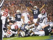  ?? Albert Cesare / Associated Press ?? Auburn running back Kerryon Johnson (21) reaches over the goal line for the go-ahead touchdown against Alabama during the Iron Bowl Saturday in Auburn, Ala.