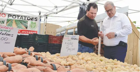  ?? [ALI WILSON / THE OBSERVER] ?? Federal Agricultur­e Minister Lawrence MacAulay (right) toured the St. Jacobs Farmers’ Market July 6 after announcing $2 million in support for beef farming research.