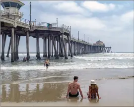  ?? LEONARD ORTIZ — SOUTHERN CALIFORNIA NEWS GROUP ?? Beachgoers enjoy the sun and sand near the Huntington Beach Pier on Thursday. Gov. Gavin Newsom ordered all Orange County beaches closed due to coronaviru­s concerns.