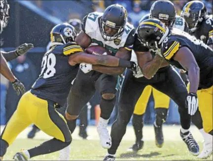  ?? DON WRIGHT - THE ASSOCIATED PRESS ?? Jacksonvil­le Jaguars running back Leonard Fournette (27) is tackled by Pittsburgh Steelers strong safety Sean Davis (28) during the first half of Sunday’s AFC divisional playoff game in Pittsburgh.