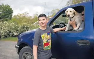  ?? HOOLEY/CHICAGO TRIBUNE ERIN ?? Zach Kurek greets his neighbor and his neighbor’s dog outside Zach’s home in Lake Station, Indiana, on May 17.