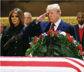  ?? GETTY IMAGES ?? PAYING TRIBUTE: President Trump, accompanie­d by first lady Melania Trump, salutes former President George H.W. Bush’s coffin late Monday in the Capitol rotunda.