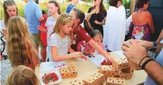  ??  ?? Children of families living in Sustainabl­e City enjoying strawberri­es grown in their community.