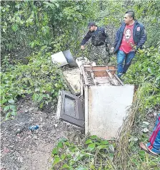  ??  ?? Agentes policiales revisan el sitio donde fue hallado el cadáver del ganadero, oculto debajo de restos de electrodom­ésticos.