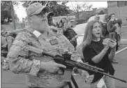  ?? Ap-john Minchillo ?? An armed counter-protester speaks with Black Lives Matter demonstrat­ors, Thursday in Louisville, Ky.