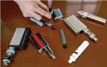  ?? Steven Senne/associated Press ?? A high school principal displays vaping devices confiscate­d from students. Texas has a tool to protect youths — the criminaliz­ation of the sale of e-cigarettes packaged to appeal to minors.