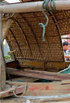  ??  ?? Le 22 mai 2018, des touristes chinois et étrangers peuvent voir un ancien bateau de pêche sur la place du village de Xipi.