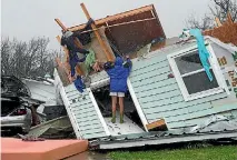  ?? PHOTO: REUTERS ?? A woman uses a coat hanger to try to retrieve an item from a destroyed house after Hurricane Harvey struck Fulton, Texas.