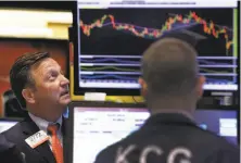  ?? Richard Drew / Associated Press ?? Specialist Thomas Facchine (left) works on the floor of the New York Stock Exchange; the Dow fell 2.84 percent Tuesday.