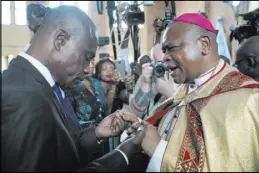  ?? Jerome Delay The Associated Press ?? Congolese opposition presidenti­al candidate Martin Fayulu is blessed Saturday by Monsignor Fridolin Ambongo, the newly appointed archbishop of Kinshasa, at Notre Dame du Congo Cathedral in Kinshasa.