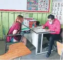  ??  ?? Una madre lleva el cuaderno de su hijo para revisión de tareas.