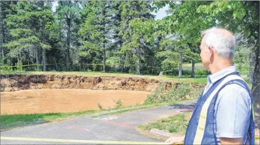  ?? DARRELL COLE – AMHERST NEWS ?? Mike Johnson, Cumberland County’s EMO co-ordinator, looks over the sinkhole in the Oxford Lions Park in Nova Scotia following a media briefing this week.