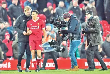  ?? — AFP photo ?? Liverpool’s German manager Jurgen Klopp (L) greets Liverpool’s English midfielder Trent Alexander-Arnold (2L) as a broadcast cameraman (2R) films after the final whistle during the English Premier League football match between Liverpool and Swansea...