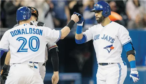  ?? CHRIS YOUNG/The Canadian Press ?? Jose Bautista, right, celebrates his two-run homer off Baltimore Orioles’ Jason Garcia with Josh Donaldson in Toronto Tuesday night.