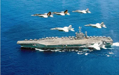  ?? GETTY IMAGES ?? While Henry Kissinger warns of a cold war with China, the US Navy patrols the world’s oceans. A combined formation of aircraft from Carrier Air Wing 5 and Carrier Air Wing 9 is pictured passing in formation above the Nimitz-class aircraft carrier USS John C Stennis.