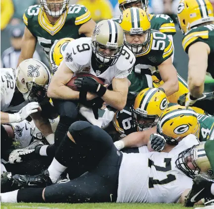  ?? DYLAN BUELL/GETTY IMAGES ?? New Orleans Saints quarterbac­k Drew Brees scores a touchdown against the Green Bay Packers on a QB sneak in the fourth quarter on Sunday in Green Bay, Wis. Brees finished the game 27 of 38 for 331 yards, also throwing for a touchdown, in the 26-17 win.