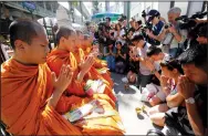  ?? AP PHOTO SAKCHAI LALIT ?? Buddhist monks hold a prayer at the Erawan Shrine at Rajprasong intersecti­on in Bangkok, Thailand, Wednesday.