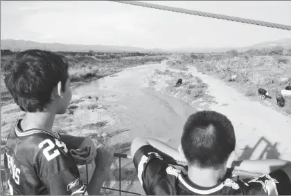  ??  ?? En imagen de archivo niños de Arizpe observan el río Sonora, luego del derrame de millones de litros de sustancias tóxicas provenient­es de la mina Buenavista del Cobre, en Cananea, el 6 de agosto de 2014 ■ Foto Cristina Gómez