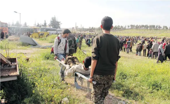  ?? GETTY IMAGES ?? A Syrian is carried into a field near the site of a car bombing that targeted buses west of Aleppo on Saturday.