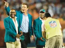  ?? ROBERT DUYOS/SUN SENTINEL ?? Mark Duper, left, and Mark Clayton, right, stand with Dan Marino during a pre-game ceremony in 2019. Duper and Clayton now enjoy watching Dolphins speedsters Tyreek Hill and Jaylen Waddle.