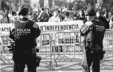  ??  ?? Mossos d’Esquadra, Catalan regional police officers, stand guard outside the regional parliament as protestors start to gather in Barcelona, Spain. — Reuters photo