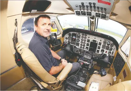  ?? JIM WELLS ?? Pilot Brian Kindrat sits in the cockpit of a plane at Springbank Airport that is used to seed clouds to reduce the impact of hail storms.