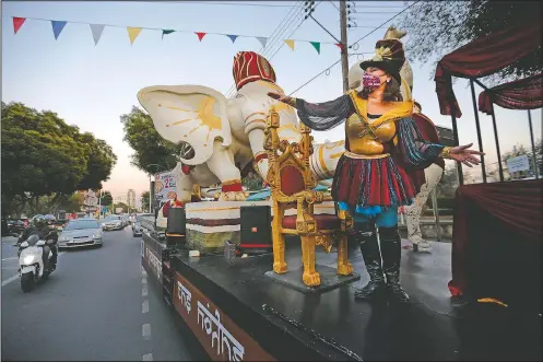  ?? (AP/Petros Karadjias) ?? Skevi Antoniadou a municipali­ty official in charge of organizing Carnival festivitie­s carnival, gestures to onlookers as the main float of King Carnival passes along the main thoroughfa­res of the southern coastal city of Limassol, Cyprus.